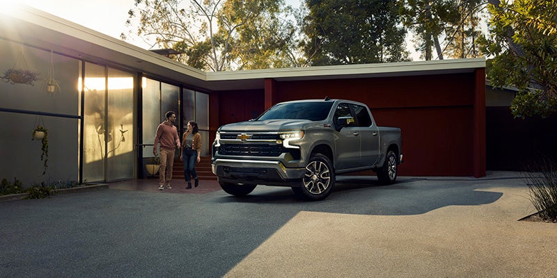A photo of a gray 2025 Chevy Silverado 1500 parked in front of a garage
